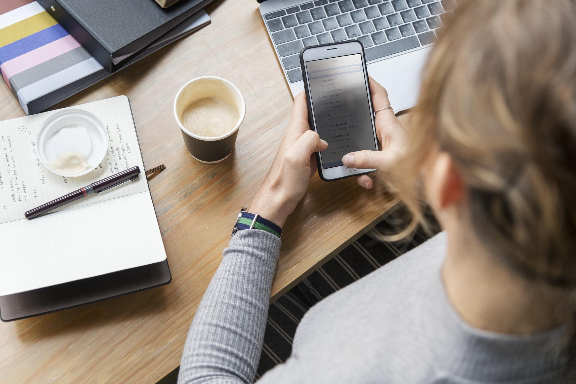 An individual with her phone and laptop