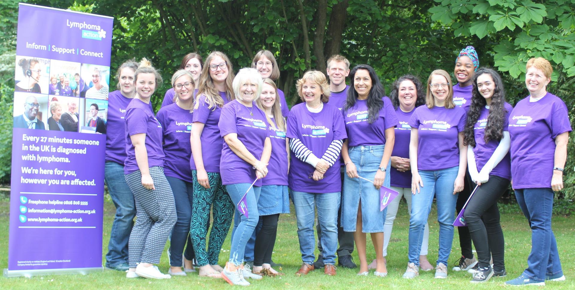Group of staff in purple t-shirts smiling 