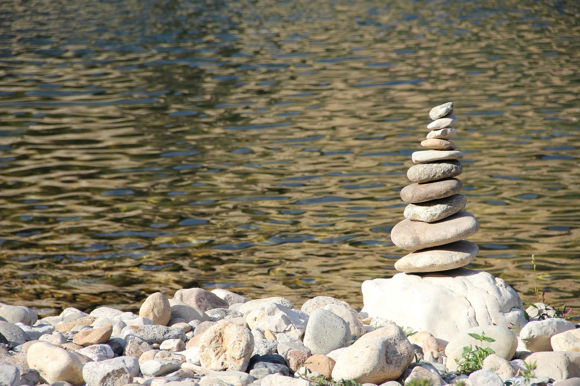 A stack of stones sits on the bank of a river