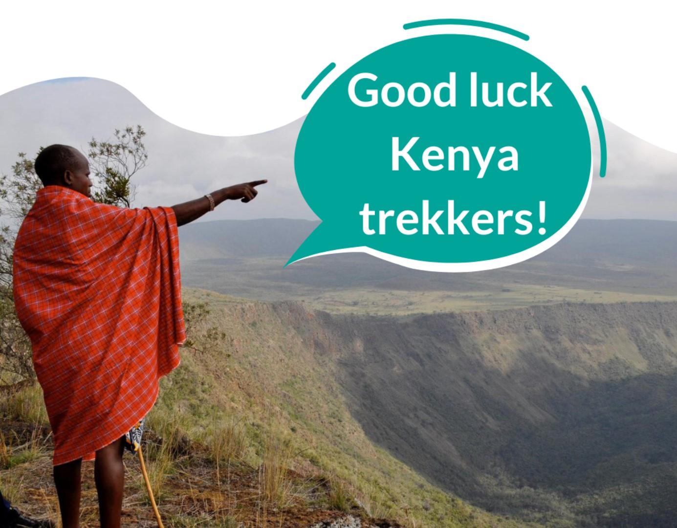 Lady stood on mountain pointing to speech bubble saying 'Good Luck Kenya Trekkers!'