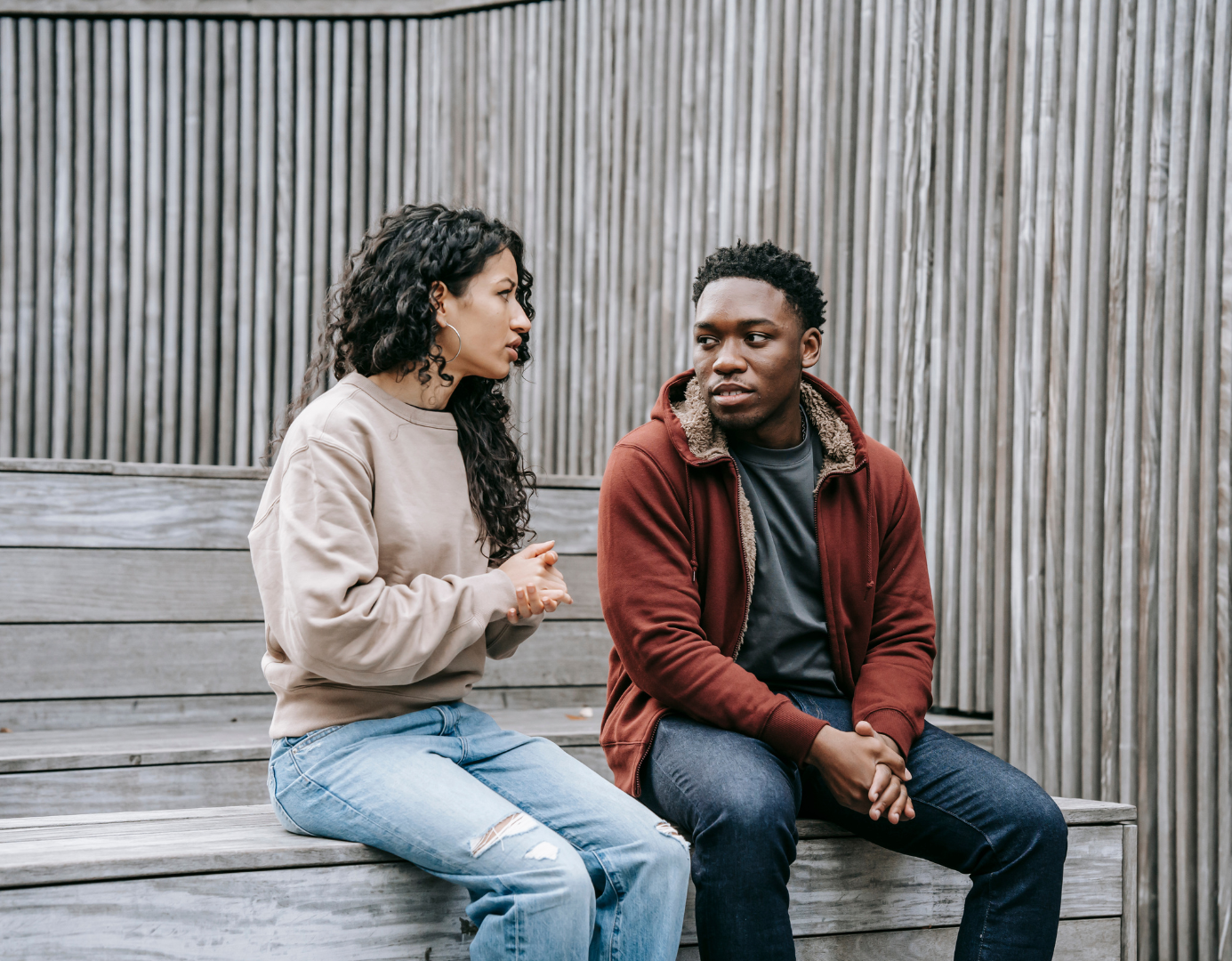 Two young people sitting outside and talking