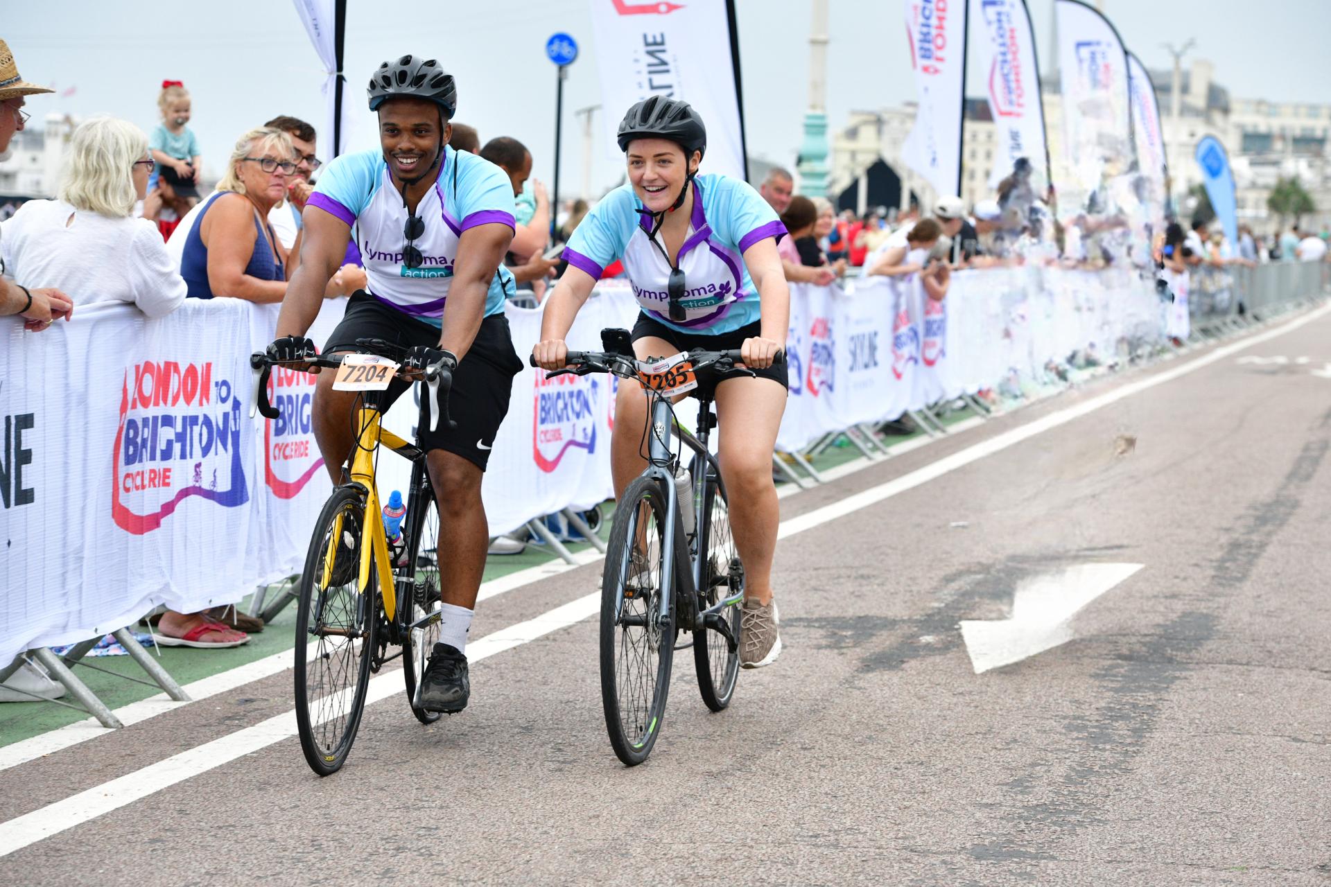 two cyclists racing to finish line on bikes 