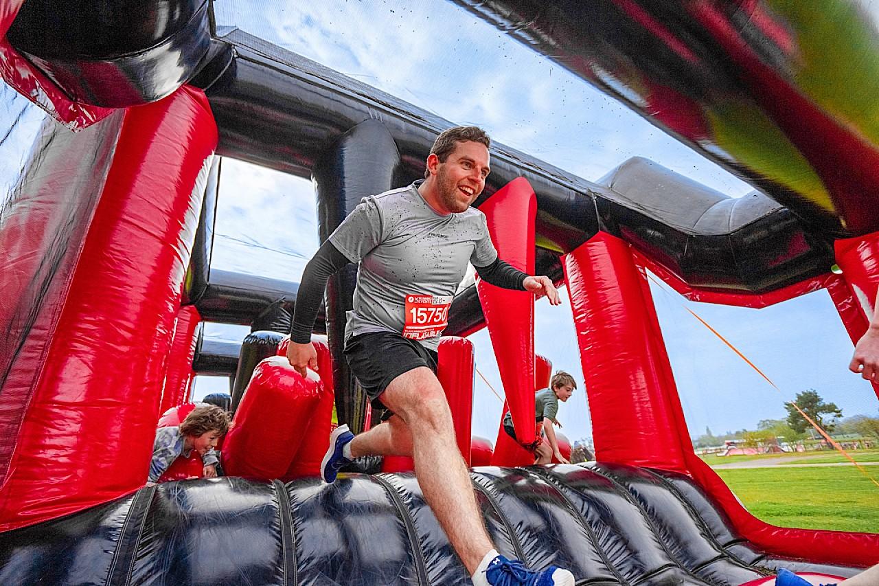 man running through inflatable course 