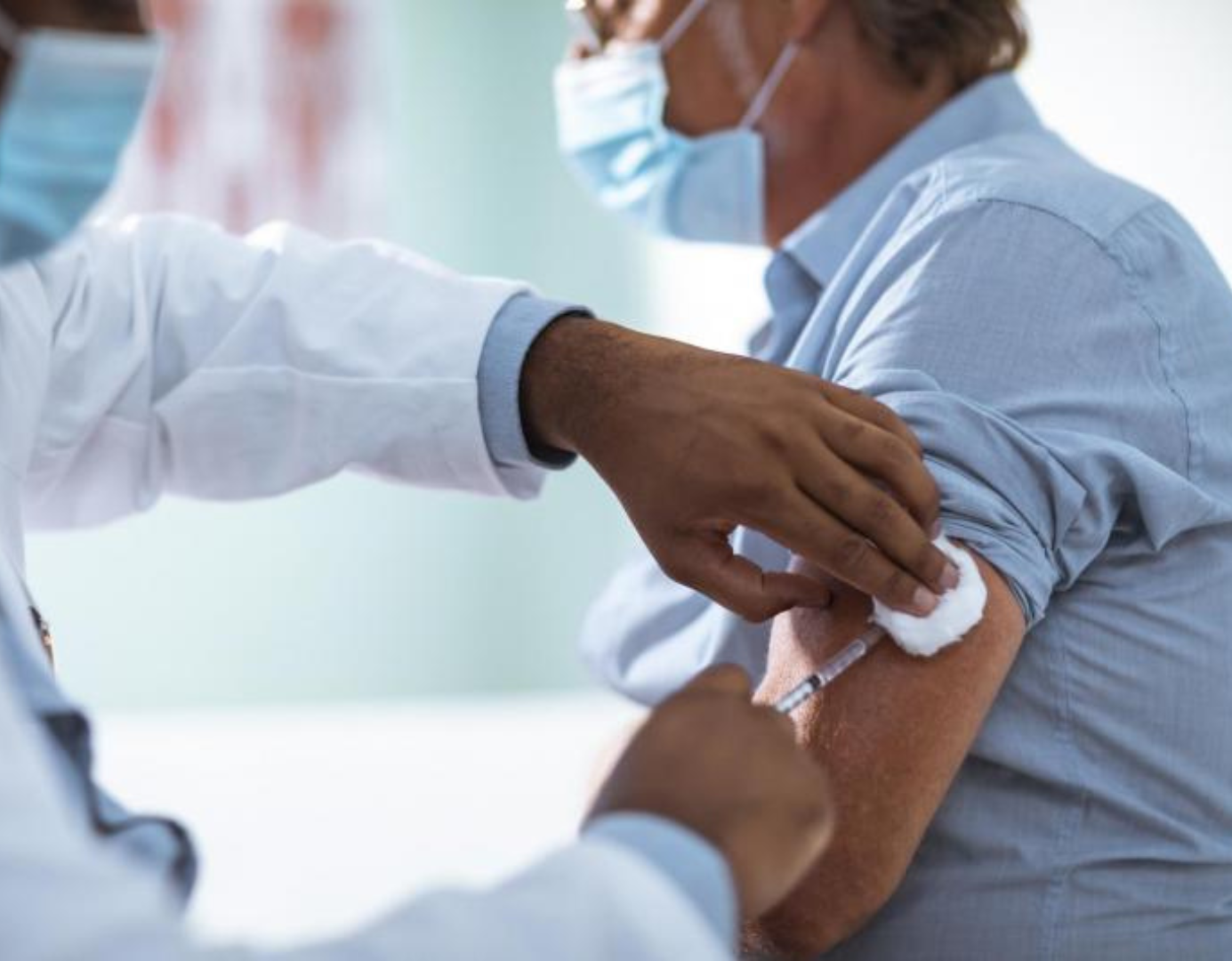 Image of a man receiving a vaccination in his left arm