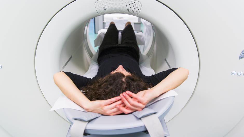 A lady lying in a cylindrical PET scan