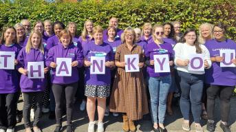 Staff holding thank you lettering