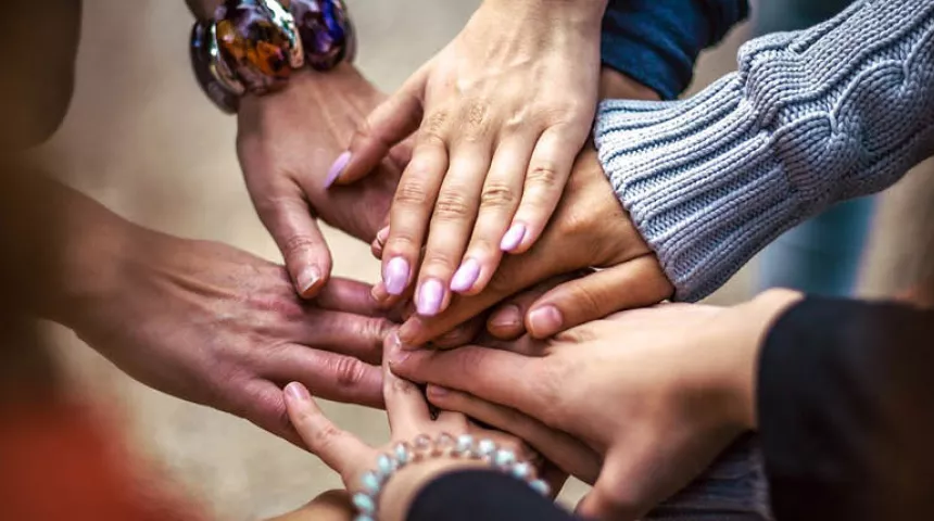 Group of people with their hands stacked on top of each other