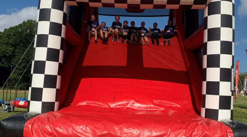 team lymphoma at the top of an inflatable side about to cross the finish line