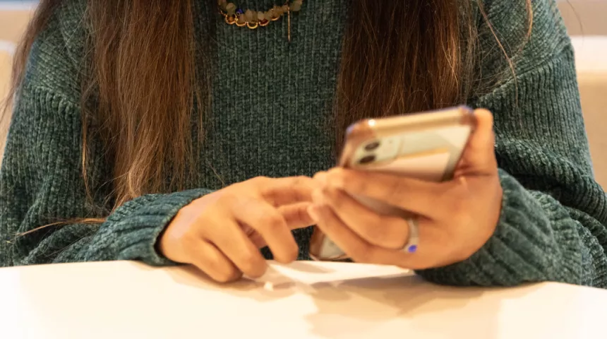 Woman's hands holding and using mobile phone