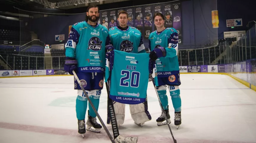 Three male ice hockey players holding up Lymphoma Action sponsored shirts