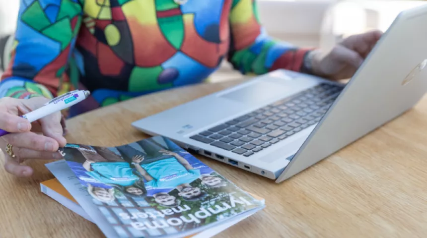 Woman on laptop with magazine