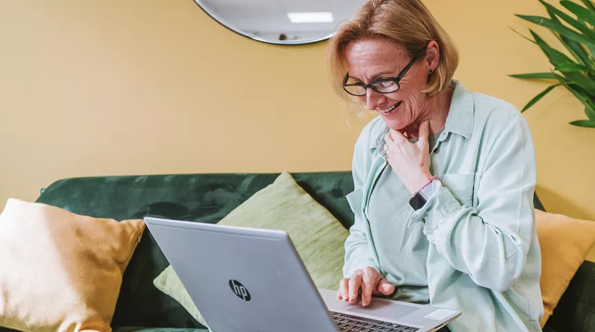 Lady sat on sofa with laptop on knee