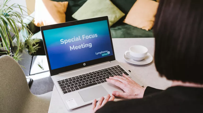 Person looking at laptop screen with 'Special Focus Meeting' wording on it