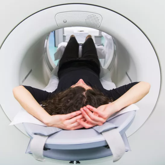 A lady lying in a cylindrical PET scan