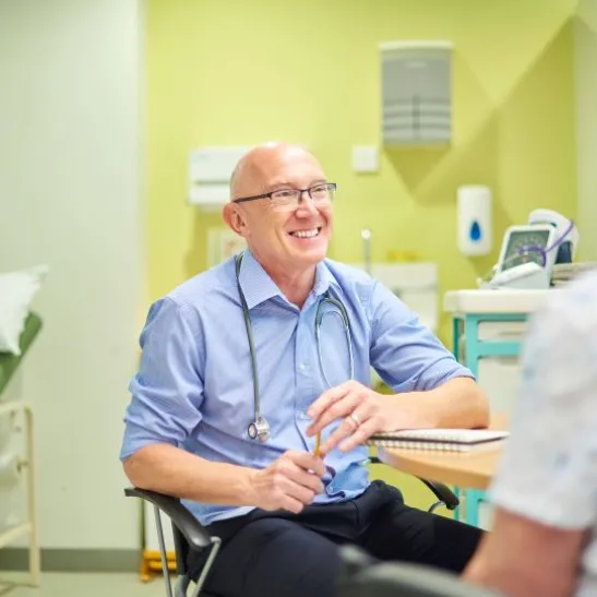 GP sitting and talking to patient