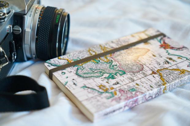 Camera and a notebook with a world map on it