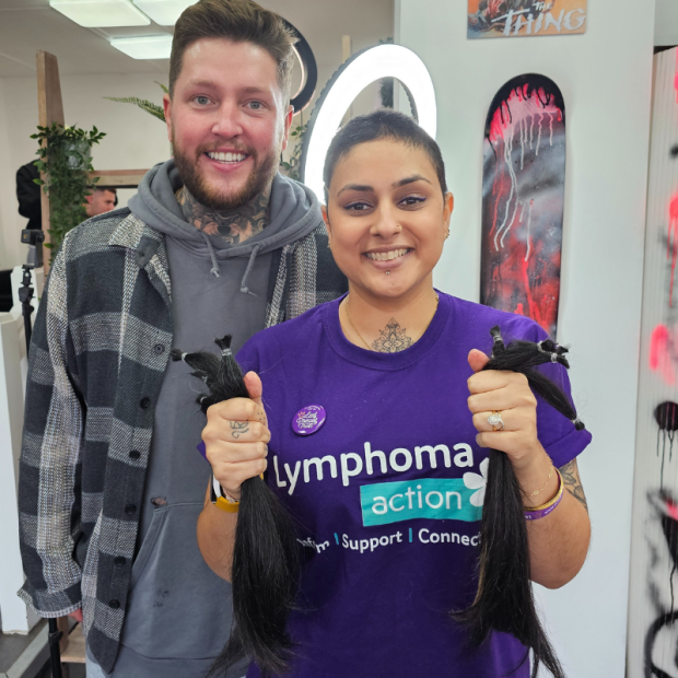 Woman holding hair bunches cut off to donate