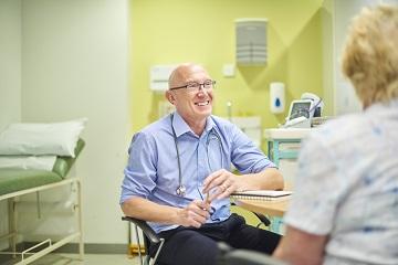 GP smiling and facing a patient